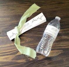 a bottle of water sitting on top of a wooden table next to a roll of tape