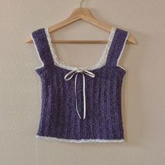 a purple top hanging on a wooden hanger