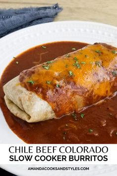 a burrito covered in sauce on top of a white plate with text that reads chile beef colorado slow cooker burritos