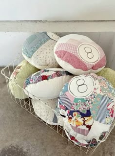 a basket filled with lots of pillows on top of a floor