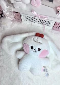 a white stuffed animal laying on top of a bed