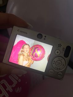 a person holding up a camera with a picture on it's screen in their hand