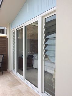 an outside patio with sliding glass doors leading to a bed and desk in the corner