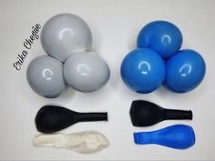 several different types of balloons on a white table with blue and black balls in the middle