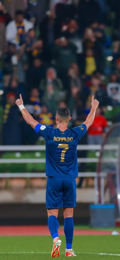 a soccer player with his arms in the air