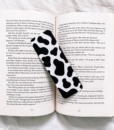 an open book with a black and white cow print cover on it's pages