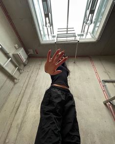 a person reaching up into the air with their hand in front of an open window