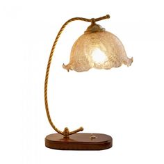 a lamp that is on top of a wooden base and has a rope attached to it