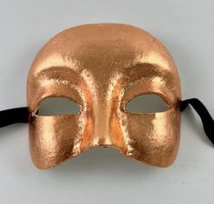 This Venetian half mask is perfect for any masquerade event.  Simple yet elegant.  The mask is handmade from paper mache and then decorated in cooper leaf. The mask's dimensions are approximately 6" wide, 5" high and 3 ½" deep. All masks are handmade in Venice, Italy.  No two masks are ever identical. Gold Venetian Mask For Halloween, Gold Full-face Masks And Prosthetics For Carnival, Venetian Half Face Mask, Gold Venetian Eye Mask For Masquerade, Gold Skull Mask, Half Face Mask, Half Mask, Costume Mask, Paper Mache