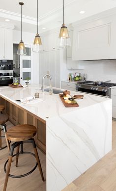 a kitchen with an island and stools next to the counter top in front of it