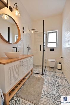 a bathroom with a sink, toilet and shower in it's own area is shown