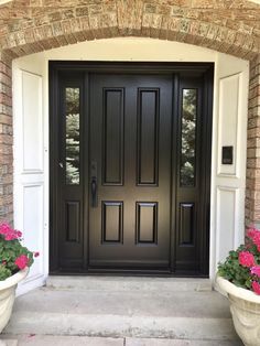 a black front door with two planters on either side