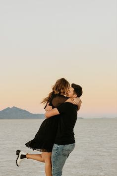 a man and woman hugging on the beach