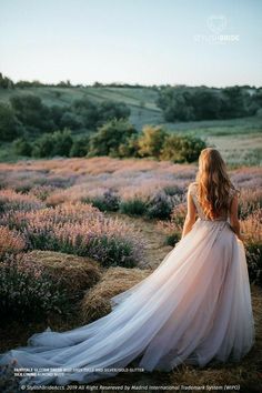 the back of a woman's dress as she walks through lavender fields