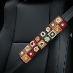 the seat belt is decorated with crochet and beadwork in various colors