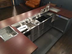 an industrial style kitchen with stainless steel appliances and wood counter tops, along with leather couches