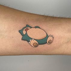 a person's arm with a cartoon character tattoo on the left side of their arm