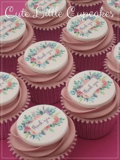 some cupcakes that are sitting on top of a pink table with white frosting