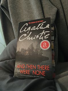 the book and then there were none is sitting on someone's lap