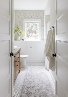 a bathroom with white walls and carpeted flooring