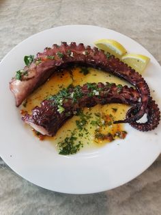 octopus rings on a plate with sauce and lemon wedges