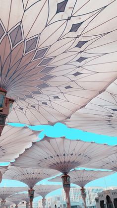 an array of umbrellas with buildings in the background