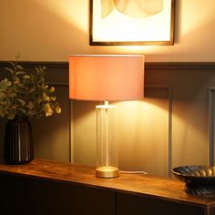 a table with a lamp and vase on it