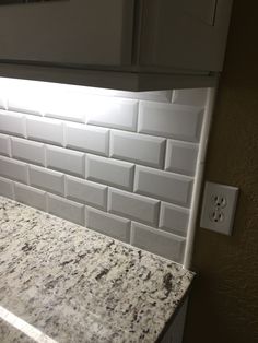 a kitchen counter top with a light shining in the middle of it's backsplash