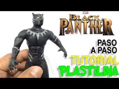 a hand is holding a black panther figurine