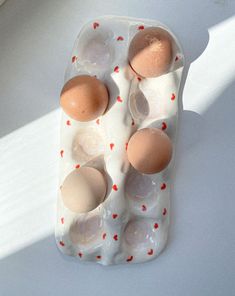 an egg carton with six eggs in it on a white surface, top view