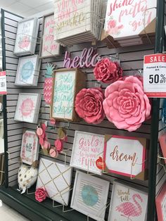 the wall is covered with pink and white paper flowers, cards, and other decorative items