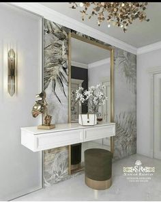 a white table topped with a mirror next to a vase filled with flowers on top of it