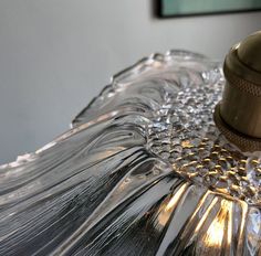 a lamp that is sitting on top of a glass table cloth with a light bulb in the middle