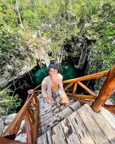 a man standing on top of a wooden bridge