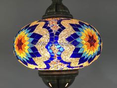 a lamp that is sitting on top of a table with a blue and yellow glass shade