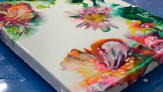 the cake is decorated with colorful flowers on it's frosting sheet and icing