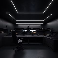 a dark room with desks, chairs and lights on the ceiling is lit up