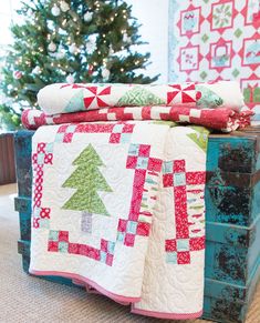 two quilts stacked on top of each other in front of a christmas tree