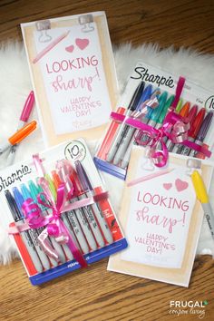 three valentine's day cards with markers and pens in them on a fur rug