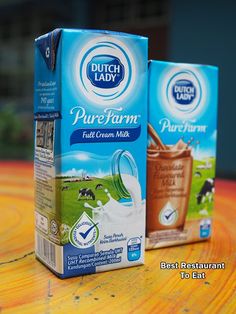 two boxes of pure farm milk sitting on a table