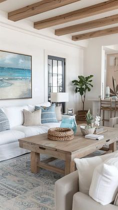 a living room filled with white furniture and lots of pillows on top of the couches