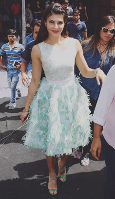 a woman in a dress is walking down the street