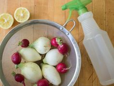 radishes and lemons are in a strainer next to a water bottle