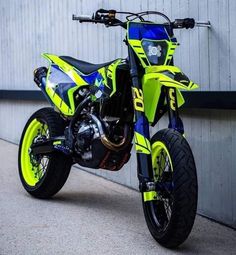 a yellow and blue dirt bike parked in front of a building