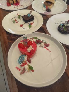 several plates with desserts on them sitting on a table