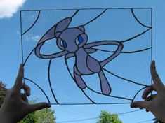 two hands holding up a stained glass window with an image of a cartoon character on it