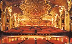 an auditorium with red seats and ornate ceiling