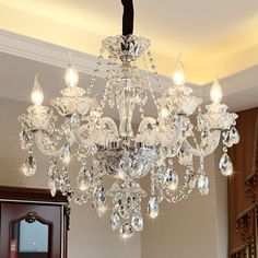 a crystal chandelier hanging from the ceiling in a room with hardwood flooring