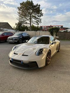 a white sports car parked in a parking lot