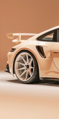 a white sports car parked in front of a brown wall